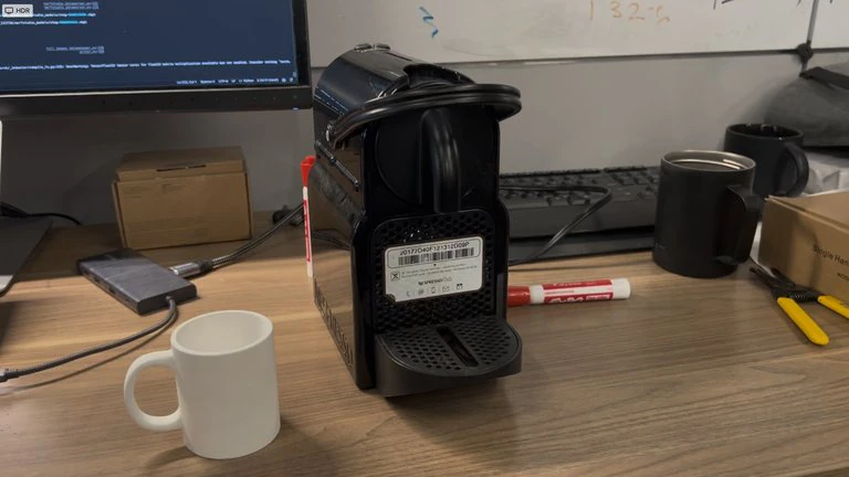 Input photograph of a coffee workspace with mugs, a coffee machine, and a kettle.